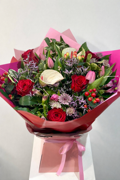 Forever in Love - A vibrant hand-tied bouquet by Octagon Flowers featuring red roses, pink tulips, seasonal flowers, berries and lush foliage, perfect for anniversaries, Valentine’s Day and romantic